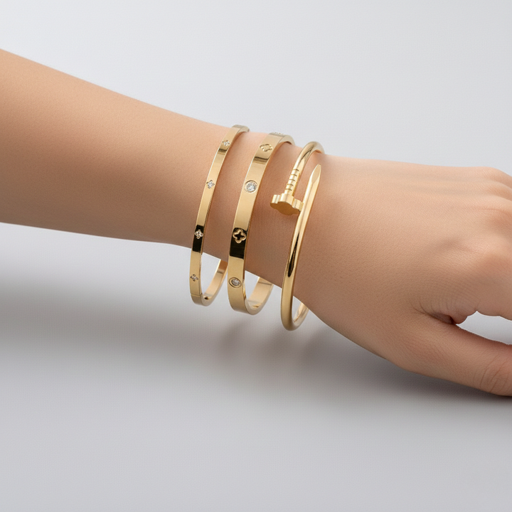 Three stainless steel floral bracelets with cubic zirconia accents, layered delicate design