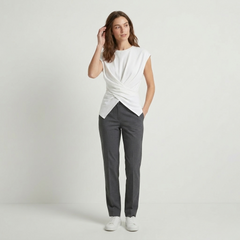 Woman in cream ruched knit top with drop shoulders and cross-tie back detail, soft ribbed texture