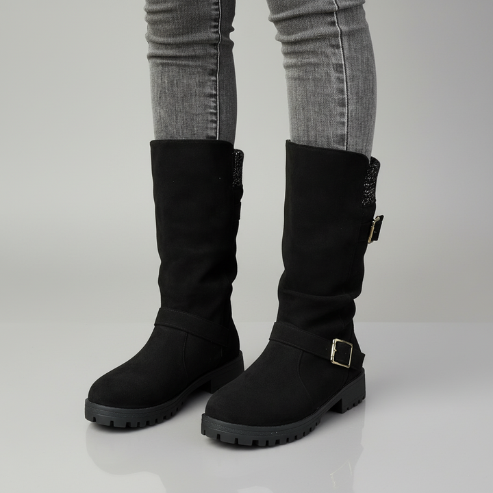 Black buckle boot with knit cuff detail, ankle-wrap silhouette, durable leather construction