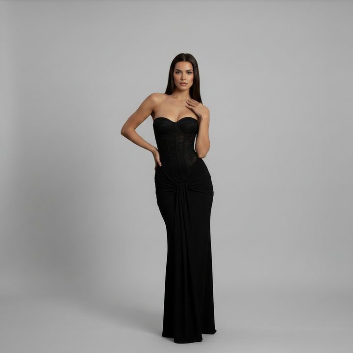 Woman in floor-length black off-shoulder gown with strapless neckline and flowing skirt silhouette