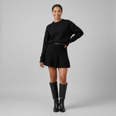 Round neck knit pullover and mini skirt set in soft ribbed fabric, styled on model in neutral setting