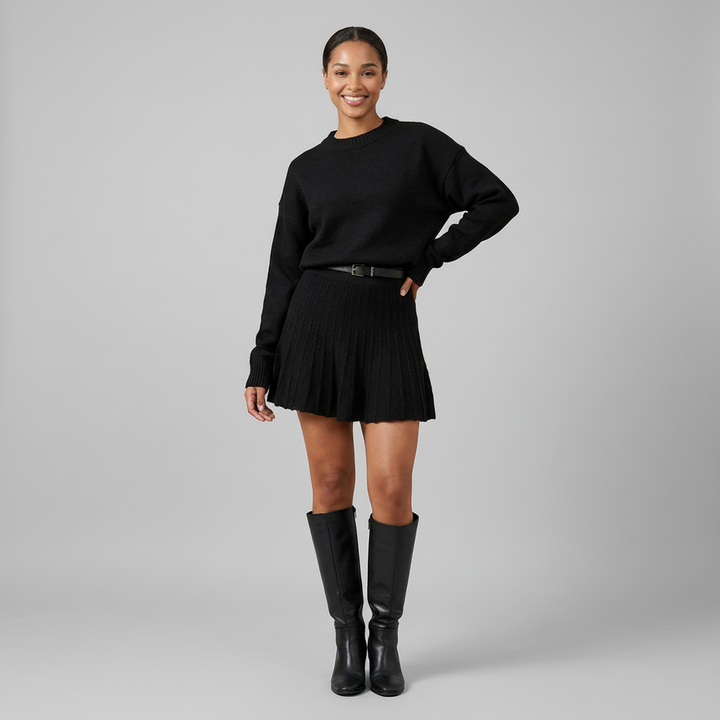 Round neck knit pullover and mini skirt set in soft ribbed fabric, styled on model in neutral setting