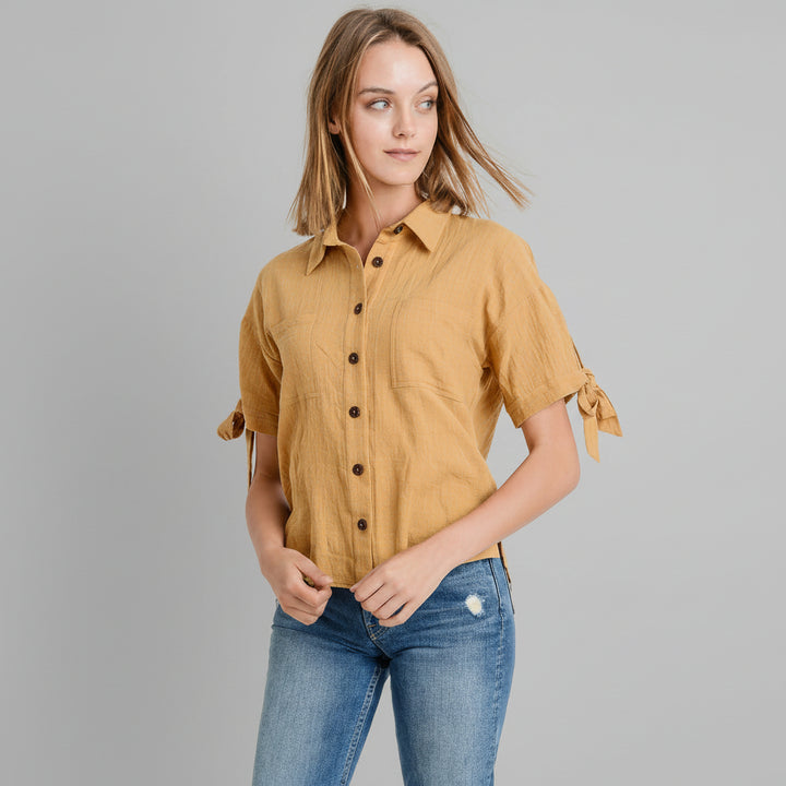Mustard button-up top with tie sleeves and contrast buttons, relaxed fit on model