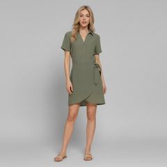 Woman in black button-down mini dress with side bow detail, linen-effect polyester, standing in natural light