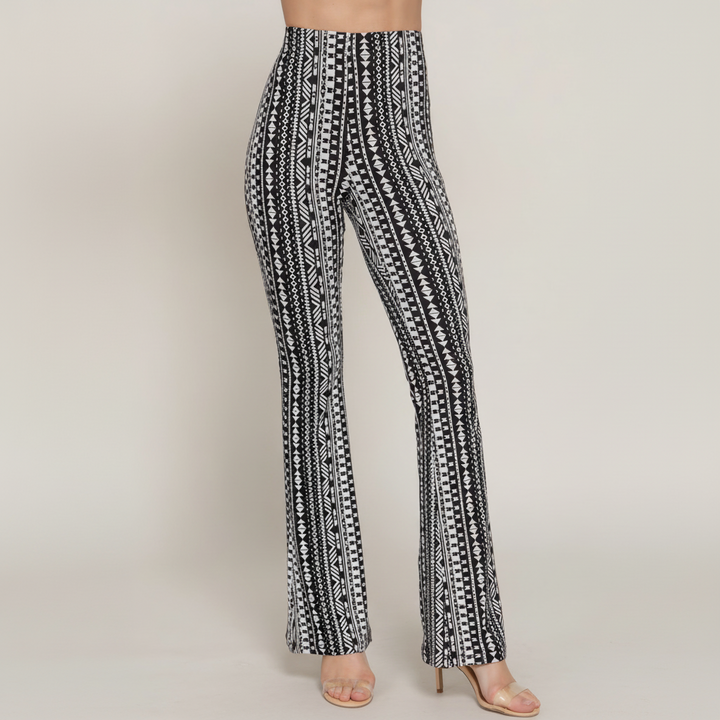 Woman in printed flare pants with elastic waist, slim fit through hips transitioning to flared hem, polyester-spandex blend