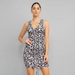 Woman in ditsy floral ruched dress with adjustable drawstring detail, stretch-knit fabric, sleeveless bodycon silhouette