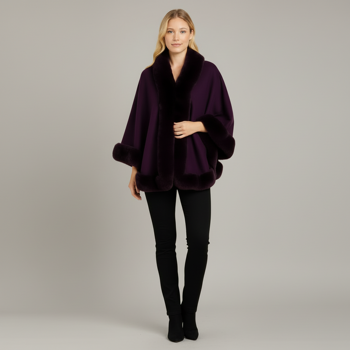 Woman wearing ivory faux fur cape jacket with open-front drape and soft fur trim at collar and cuffs