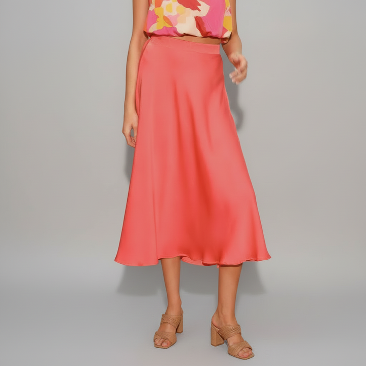 Woman wearing chartreuse pleated silk midi swing skirt with smooth drape and feminine movement
