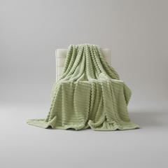 Oversized fluffy cream plush blanket draped over neutral sofa with soft texture detail