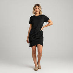 Woman in ruched wrap summer dress with contoured silhouette, high-stretch fabric, short sleeves, round neckline