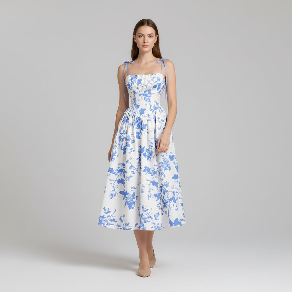 Woman in floral print mini dress with tie shoulder straps, fitted silhouette, lightweight fabric detail
