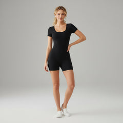 Black square neck bodysuit with contoured fit and built-in shorts, styled on model in neutral studio setting