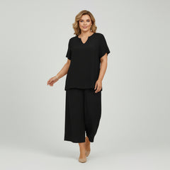 Woman in solid color v-neck top and wide-leg pants set, relaxed silhouette, soft breathable fabric