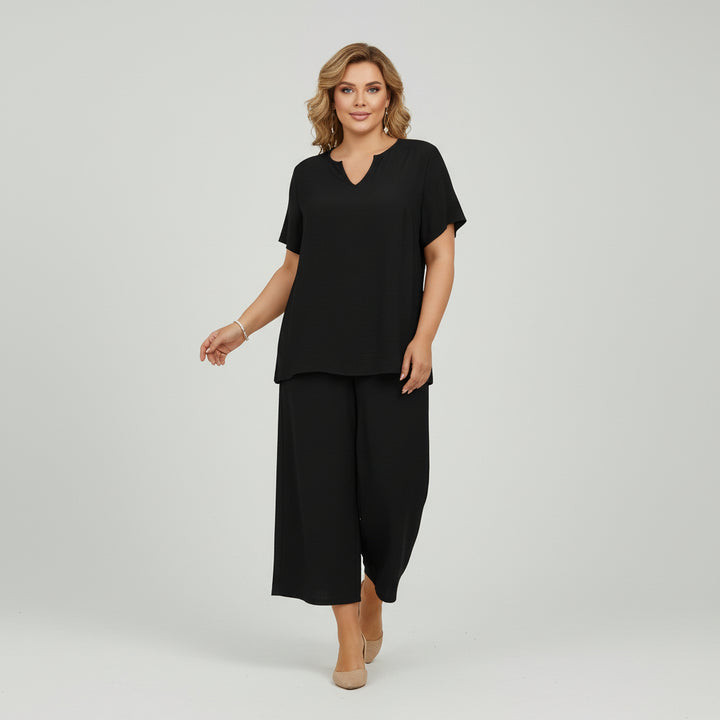 Woman in solid color v-neck top and wide-leg pants set, relaxed silhouette, soft breathable fabric