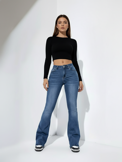 Woman wearing high-rise bell bottom jeans in dark denim with dramatic flare silhouette, full-length view