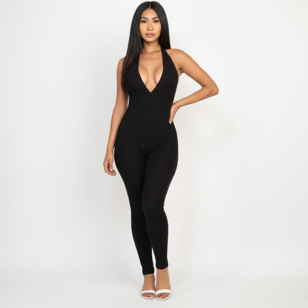Woman in black ribbed halter jumpsuit with plunging V-neckline and adjustable tie, full-length body-contouring silhouette