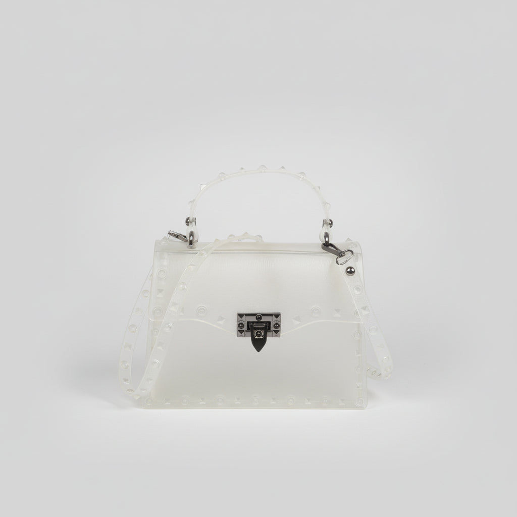 Structured clutch with metal stud detailing in hand, sleek industrial finish against neutral backdrop