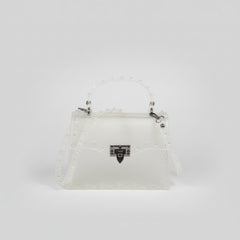 Structured clutch with metal stud detailing in hand, sleek industrial finish against neutral backdrop