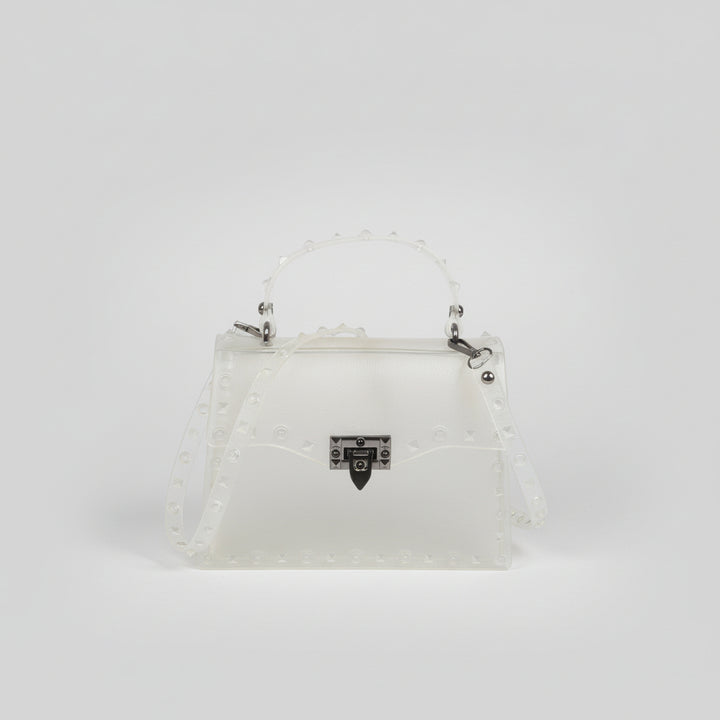 Structured clutch with metal stud detailing in hand, sleek industrial finish against neutral backdrop