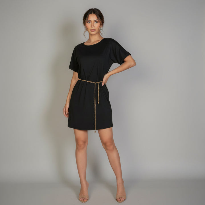 Woman in fuchsia mini dress with side pockets and double-folded sleeves, lightweight fabric, casual silhouette