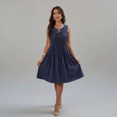 Woman in olive pleated dress with knotted cut-out waist detail, loose fit silhouette, lightweight polyester fabric