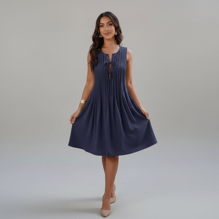 Woman in olive pleated dress with knotted cut-out waist detail, loose fit silhouette, lightweight polyester fabric