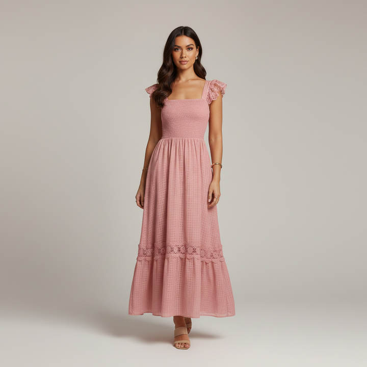 Woman wearing a pink dress with ruffled sleeves on a plain background